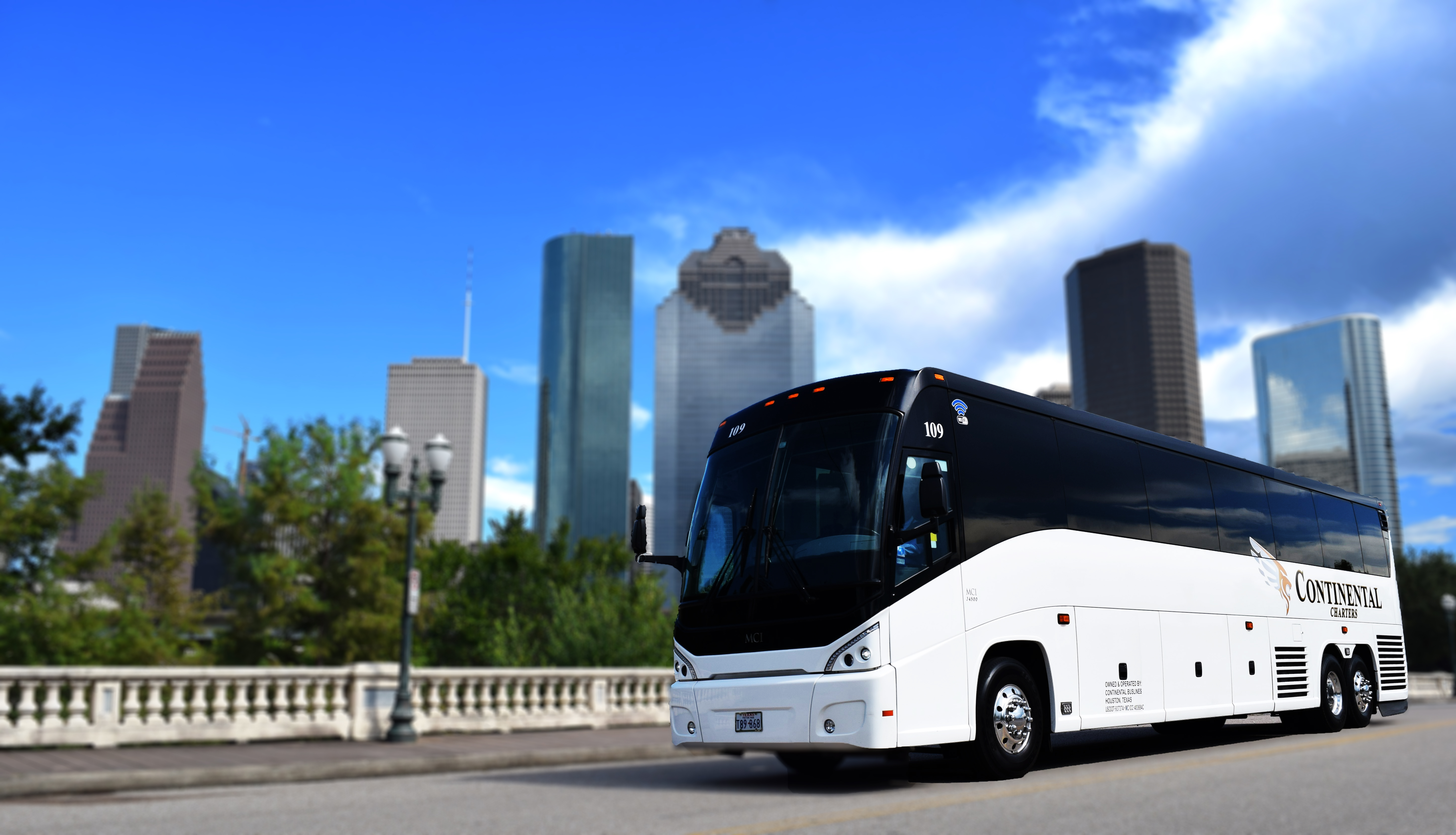 Houston City Skyline With White Luxury Bus Driving On Bridge